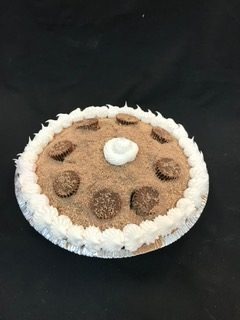 An ice cream pie with a cookie crumb top, ringed with piped whipped topping