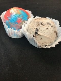 Two party dips in paper cupcake liners — one rainbow-swirled, one cookies and cream